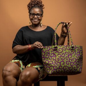 Femme portant un sac cabas en wax vert et rose